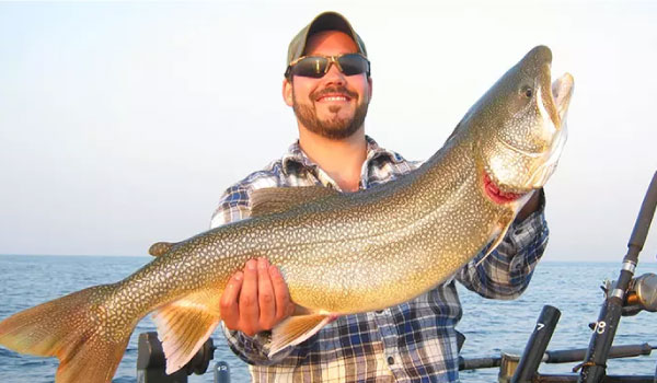 Man Holding a Fish on Lake Michigan