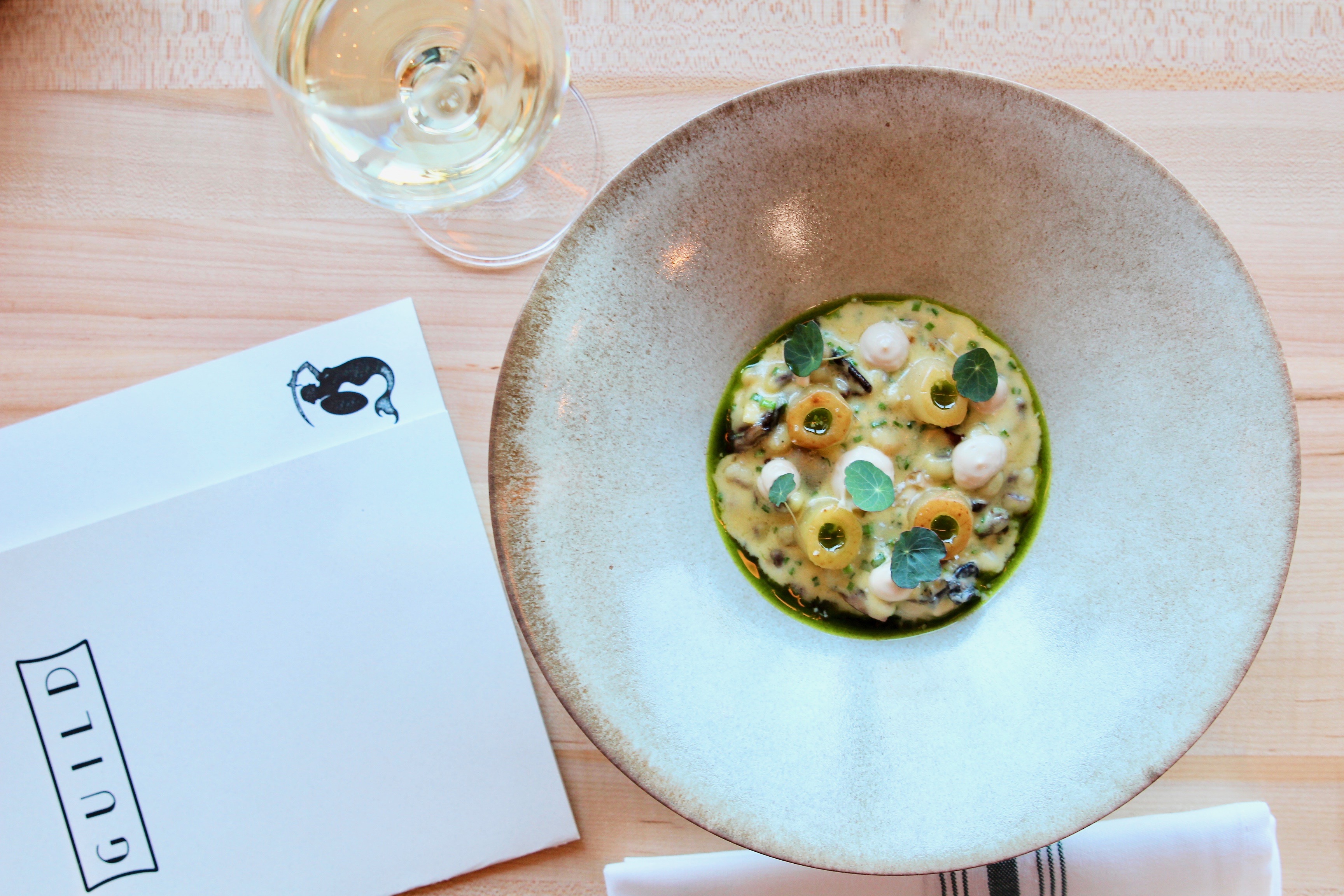 Oyster Sabayon and wine with menu at Guild restaurant in Austin Texas