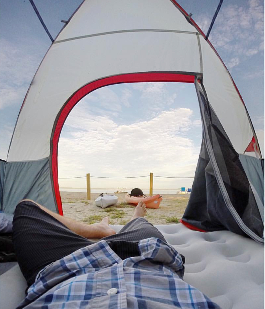 Man in Camping Tent Overlooking Kayaks and The North Landing Beach 