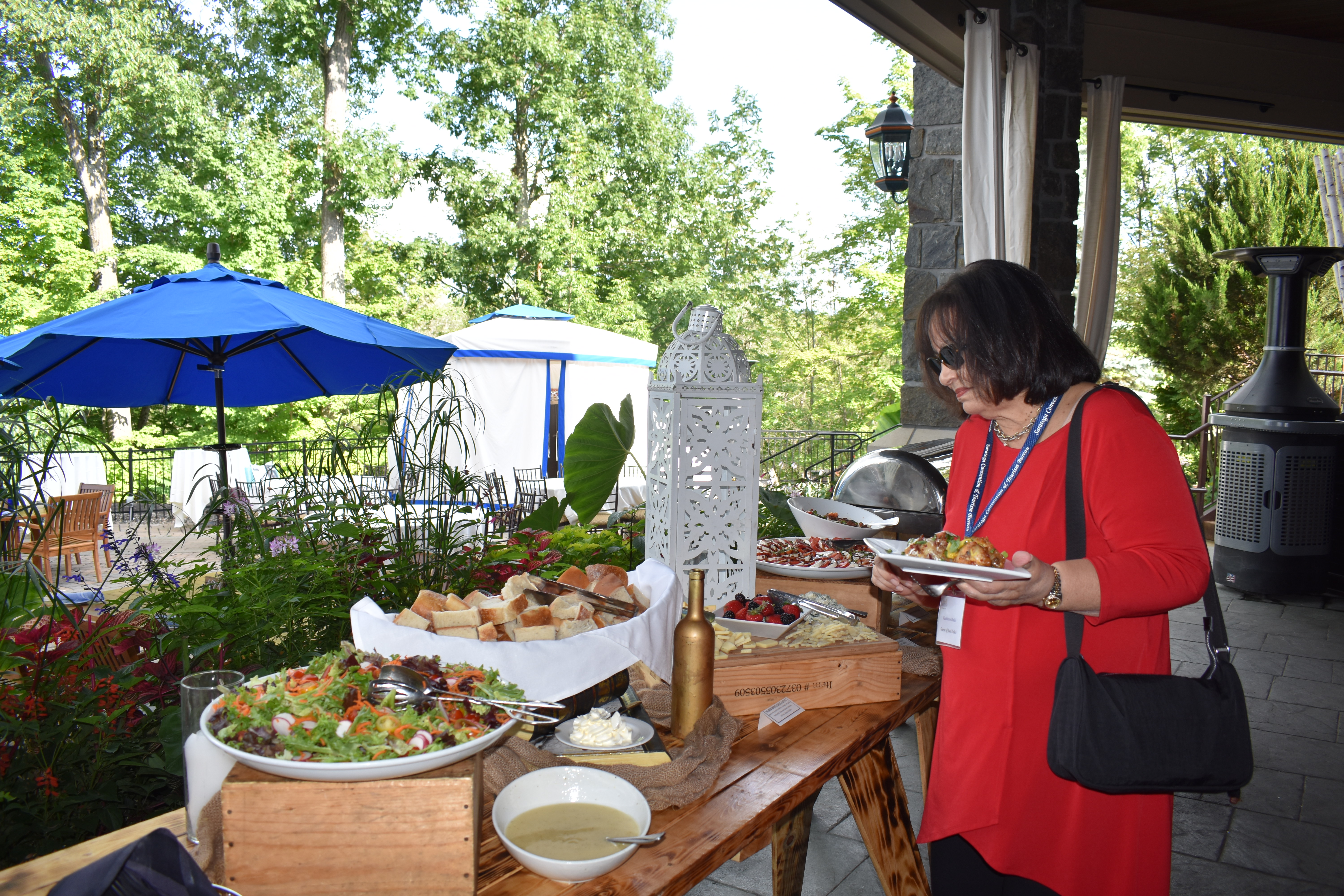 Woman at networking event at Saratoga National Golf Club grabbing food from buffet