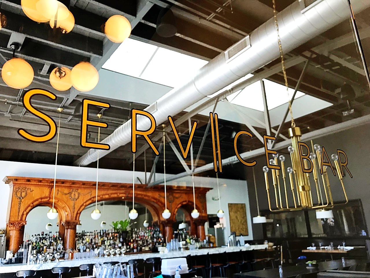 Close-up of Service Bar's store signage with interior of bar in background