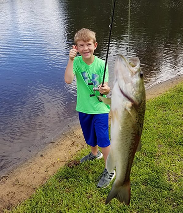 Boy fishing on lake shore - Stock Photo - Dissolve