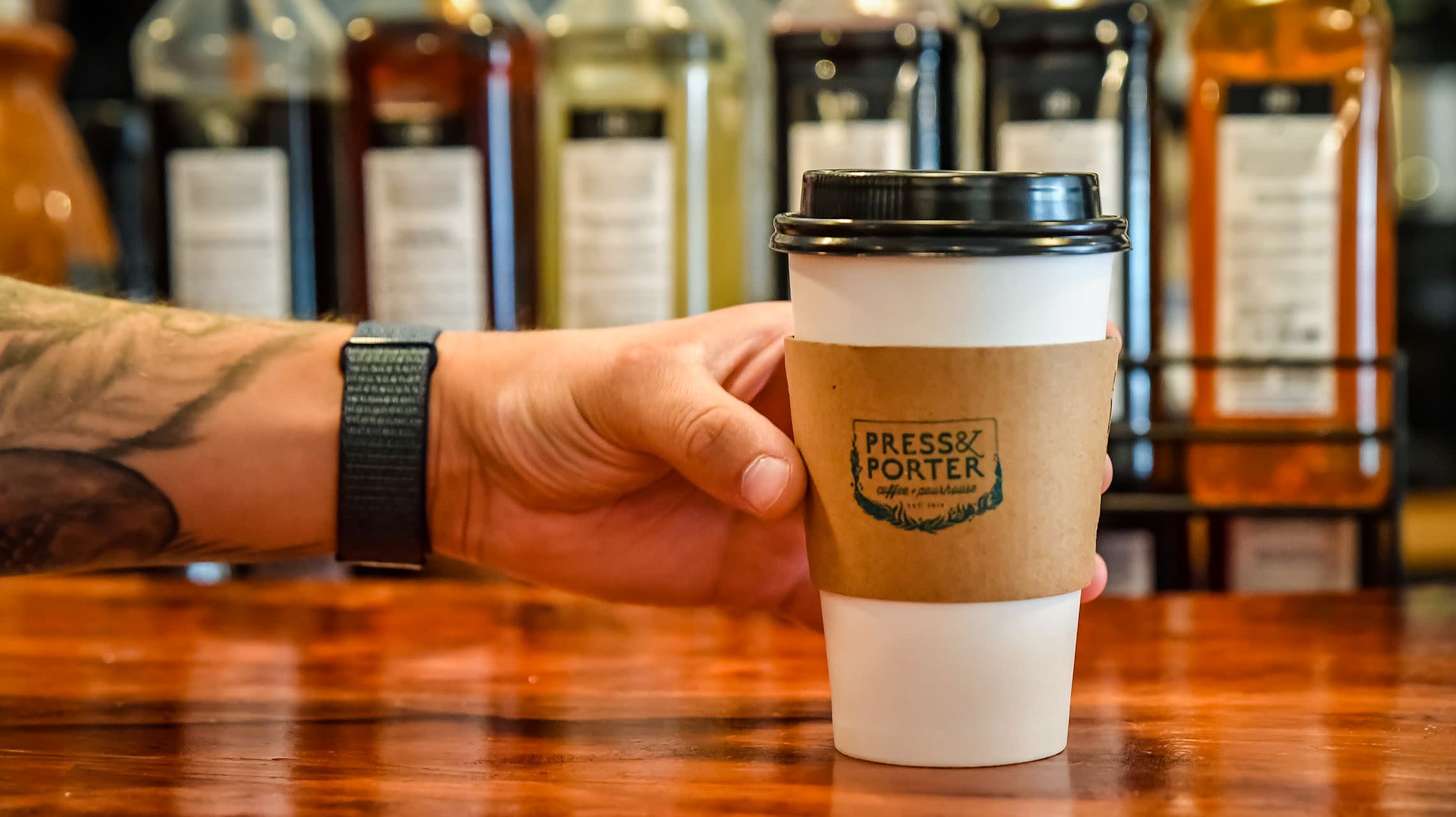 hand holding to-go coffee cup