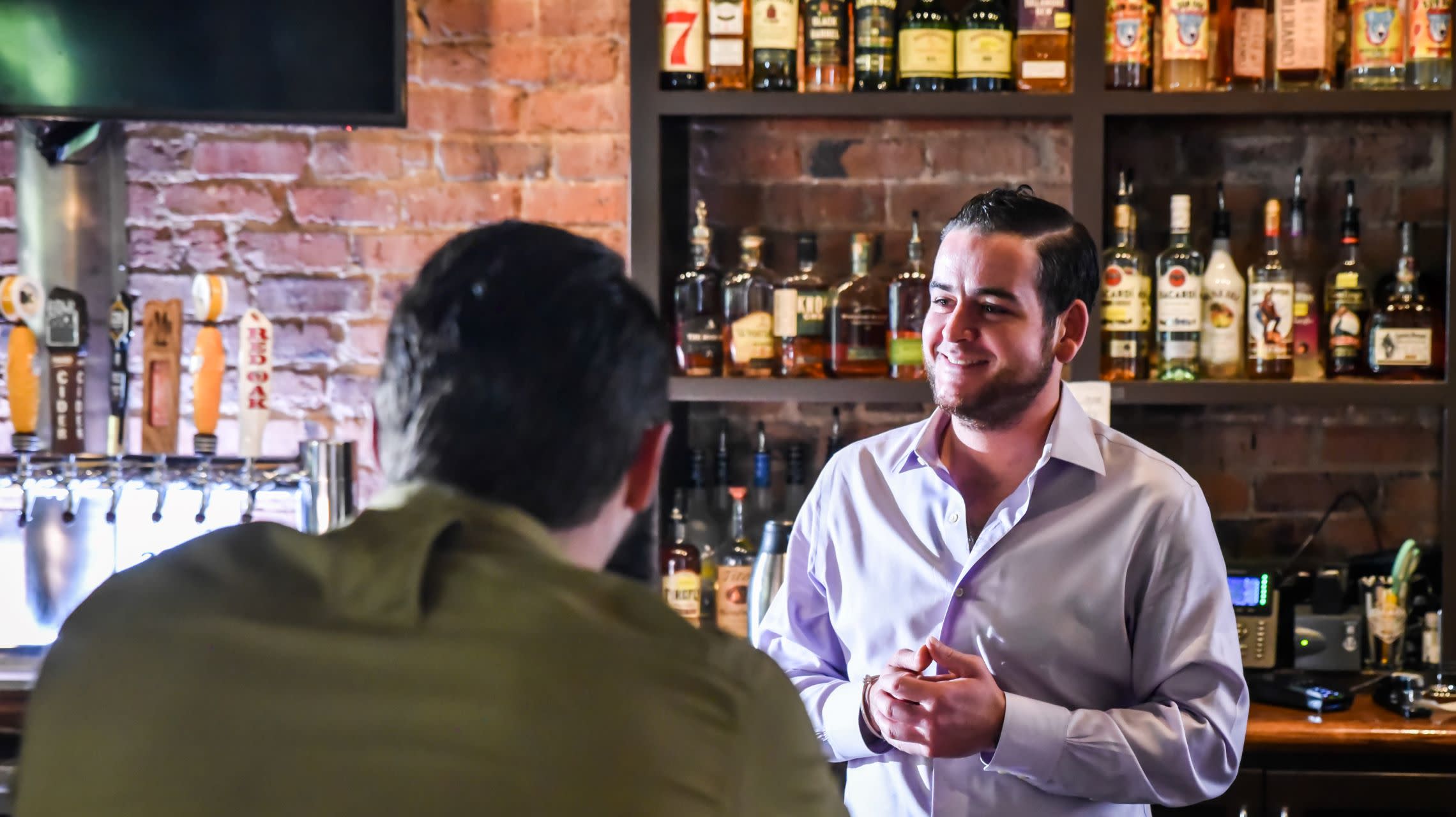 server helps guest at bar