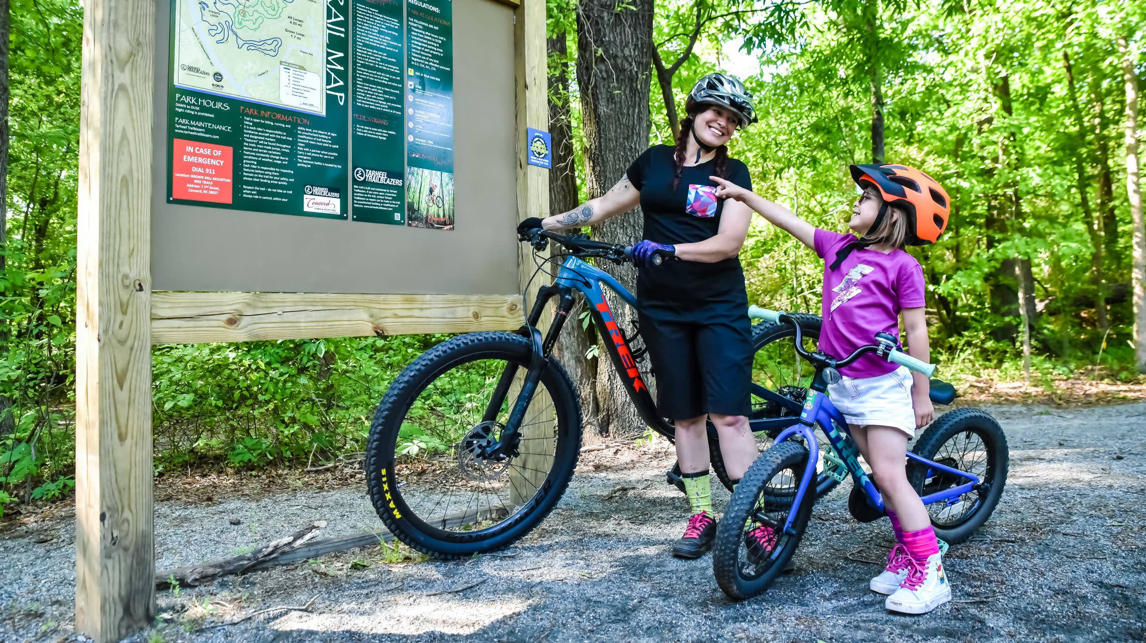 mother and daughter with bicycles at trailhead