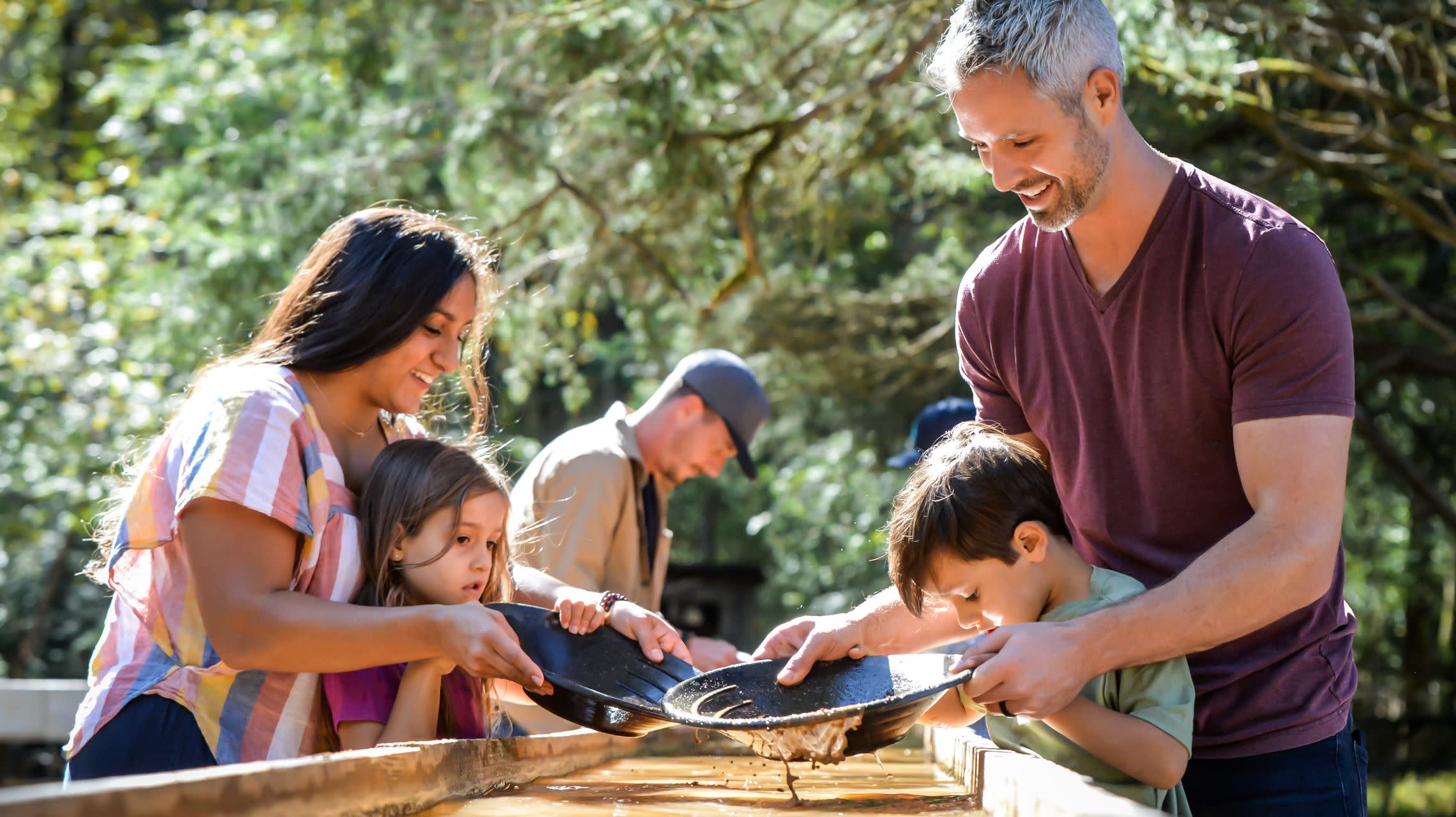 a family of four searches for gold in the gold panning area of Reed gold Mine