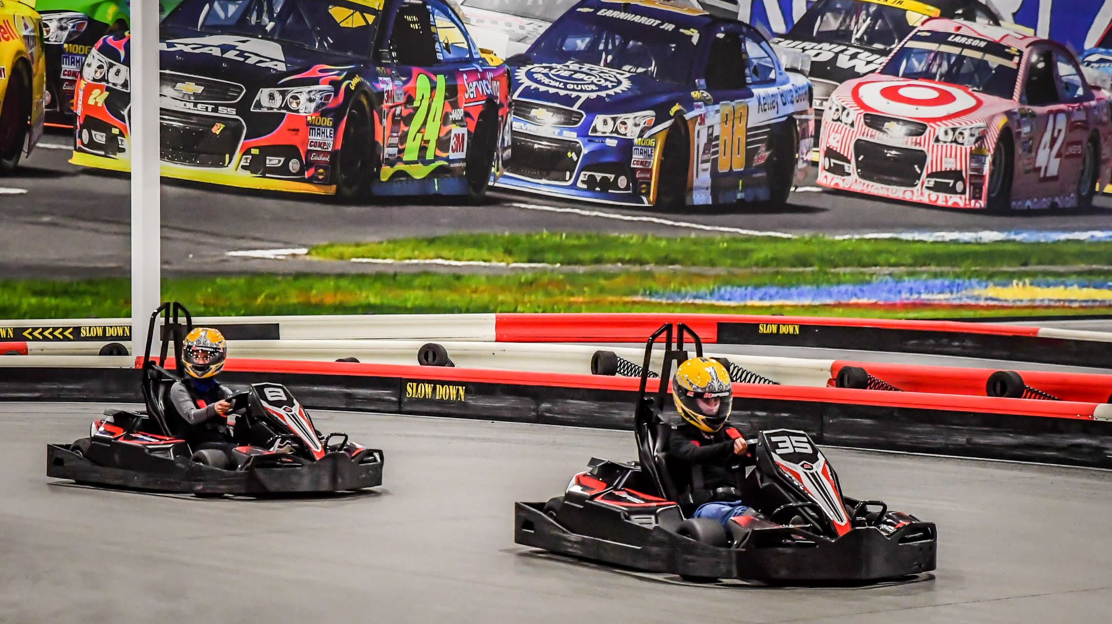 go kart riders race around track