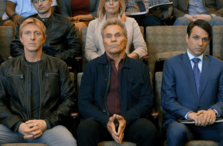 Three men sit next to each other. Still from Heald, Hurwitz, Schlossberg, Cobra Kai (Season 3, Episode 8).