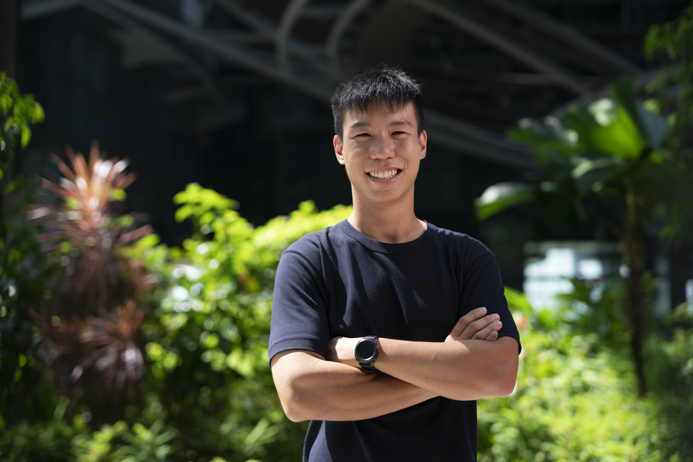 Team of colleagues smiling and talking while working at computer desks with monitors displaying data