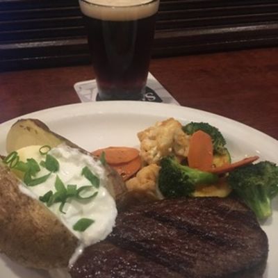 Pub Steak with potatoes veggies and a glass of dark beer.