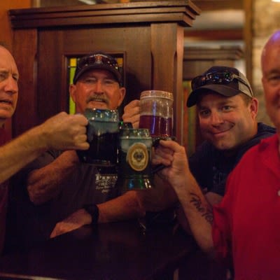 Customers cheering and posing with beer steins.