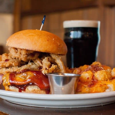 BBQ Bacon Cheeseburger with dip and a glass of dark beer.