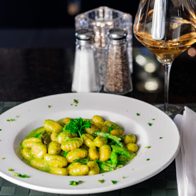 Green beans dish with salt and pepper shakers and a glass of white wine