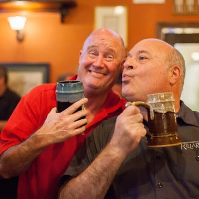 Customers smiling and drinking beer.