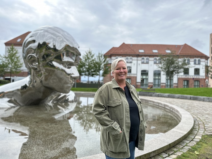 Cathrine Brynildsen lager podcast fra og om Østre bydel. Hun bor selv i gamle Kirkegata skole, som ses i bakgrunnen. (foto: Ole Christian Foss) 