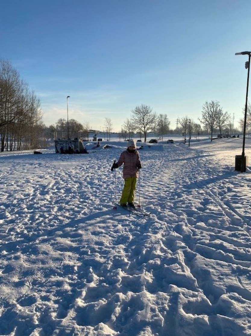 jente står på ski i snøen