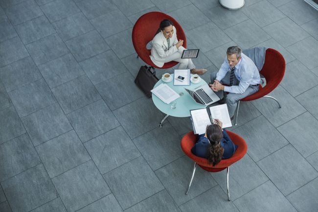 Employees discussing strategy at coffee table Employees discussing strategy at coffee table