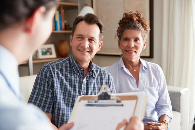 Senior Couple Meeting With Male Financial Advisor At Home