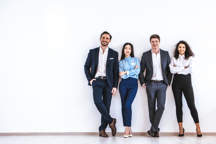 The business people standing on the white wall background People - teamwork