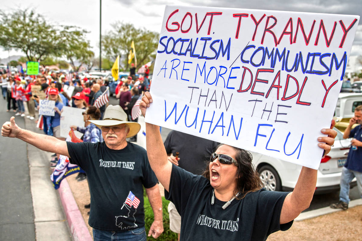 Re-Open protesters hold signs saying "Govt. Tyranny Socialism/Communism Are More Deadly Than The Wuhan Flu"
