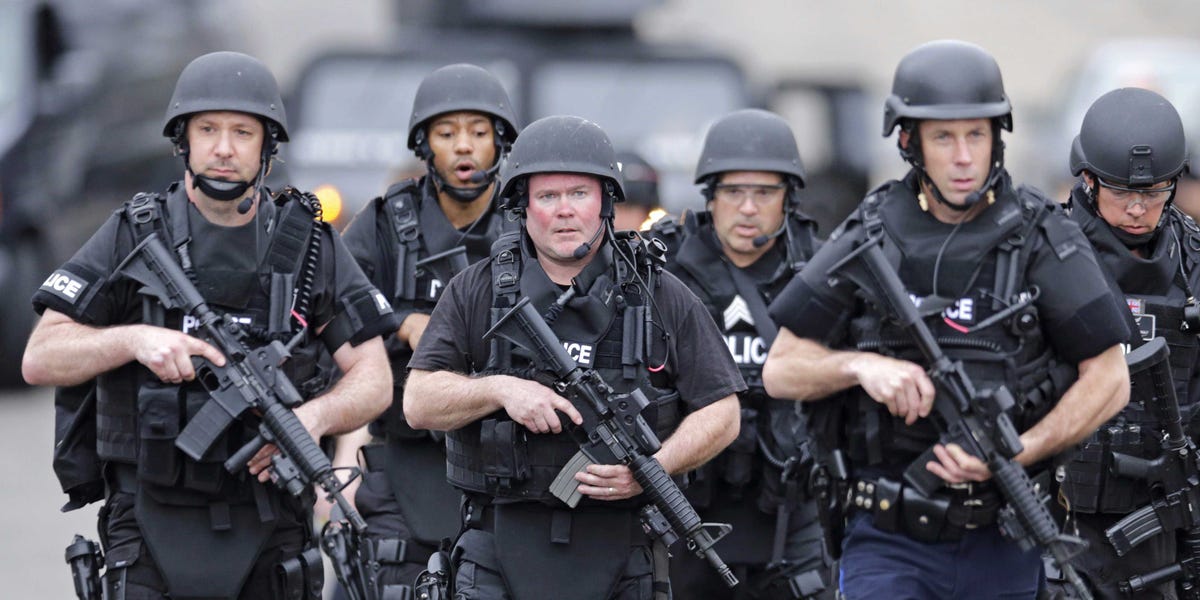 Police carrying assault weapons.