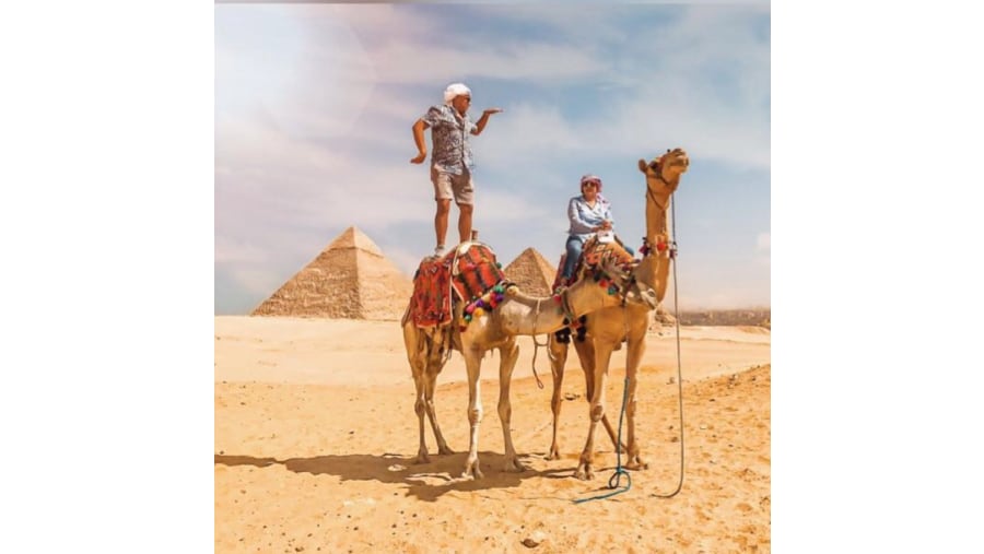 Tourists Riding a Camel by the Giza Pyramids