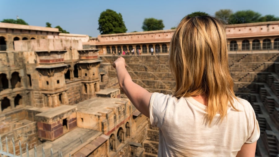 A Girl-Traveler-Pointing-famous Stepwell Chand Baori.
