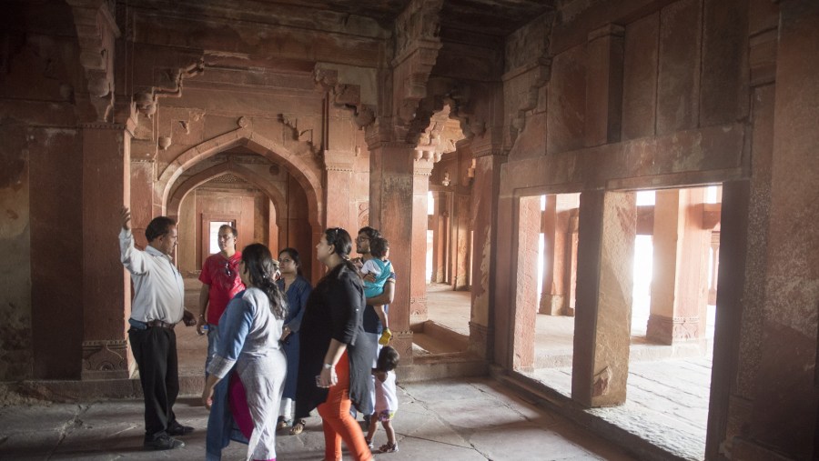 Visitors listen to a guide at the palace at Fatehpur Sikri.