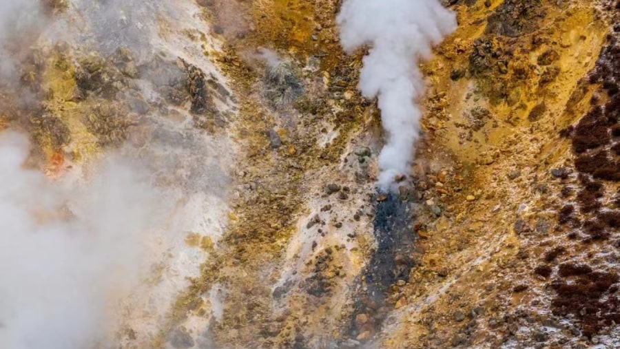 Steam rising from mountainside in Icelandic geothermal landscape in the remote Kjoslur