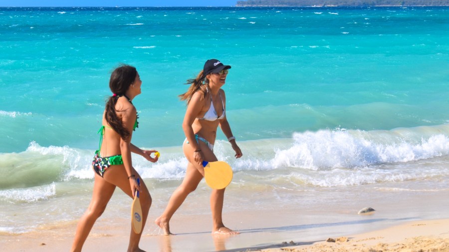 Tourists Playing Tennis At The Beach