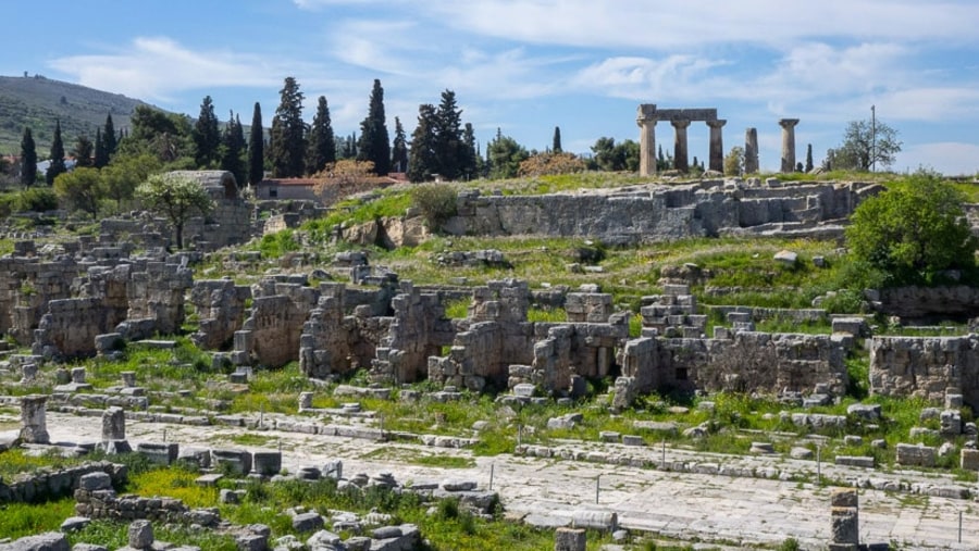 See the ruins of Corinth in Greece