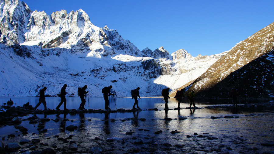 trekkers crossing Gokyo Lake 