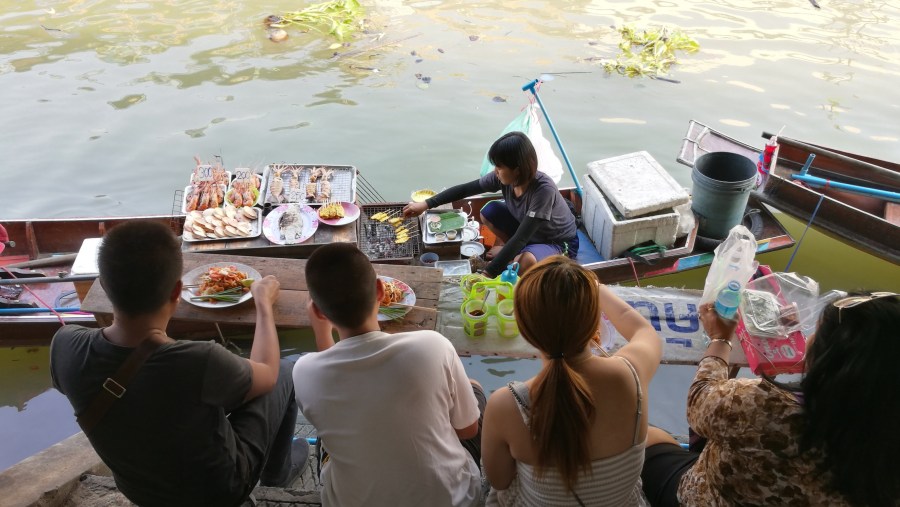 Eating beside canal at boat shop, Amphawa floating market. 