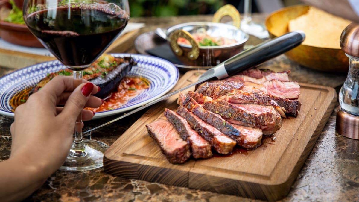 seasoning medium steak with salt grinder