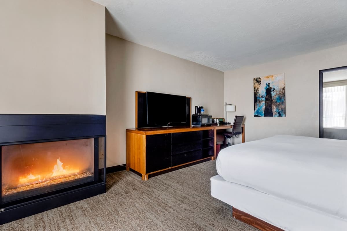 king bed with fire place and TV with desk next to it