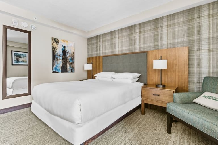king bed with nightstand and lamp plus sitting chair