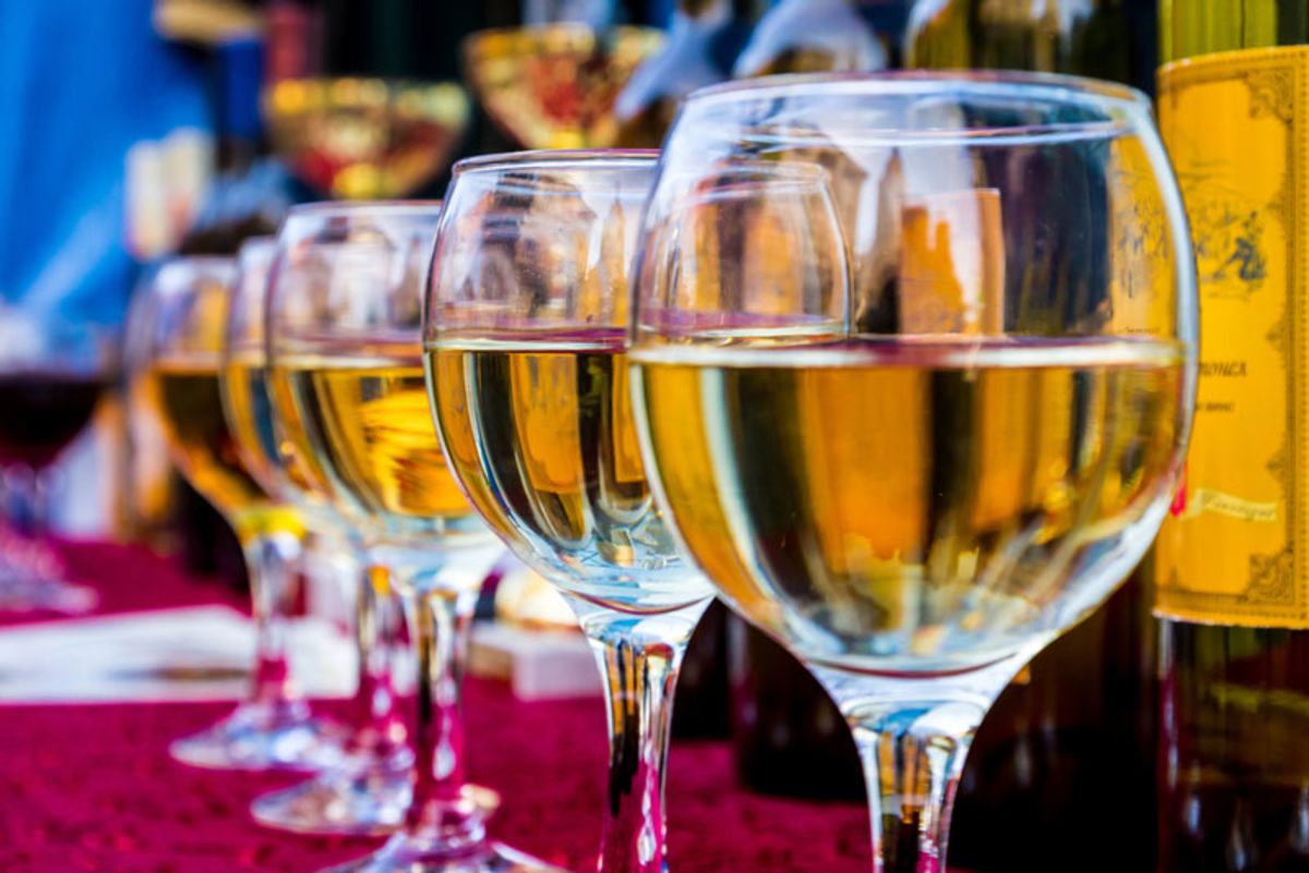 close-up-of-white-wine-glasses-on-colorful-table