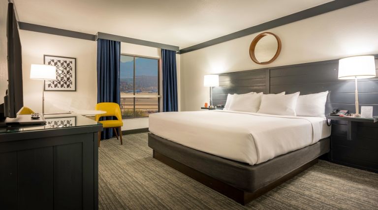 One king bed next to window with airport view.