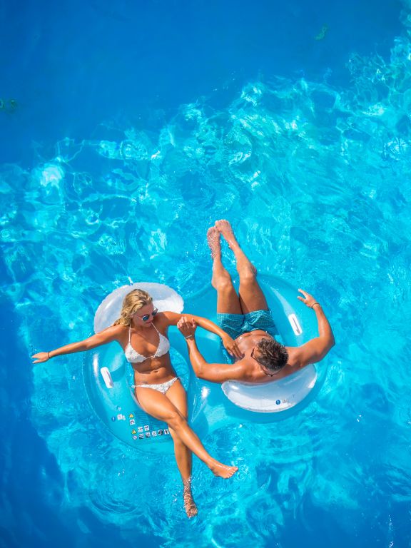Couple in pool on floats