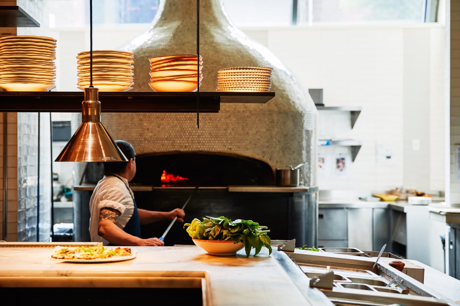 leuca dining, chef puts pizza to cook in the oven Image