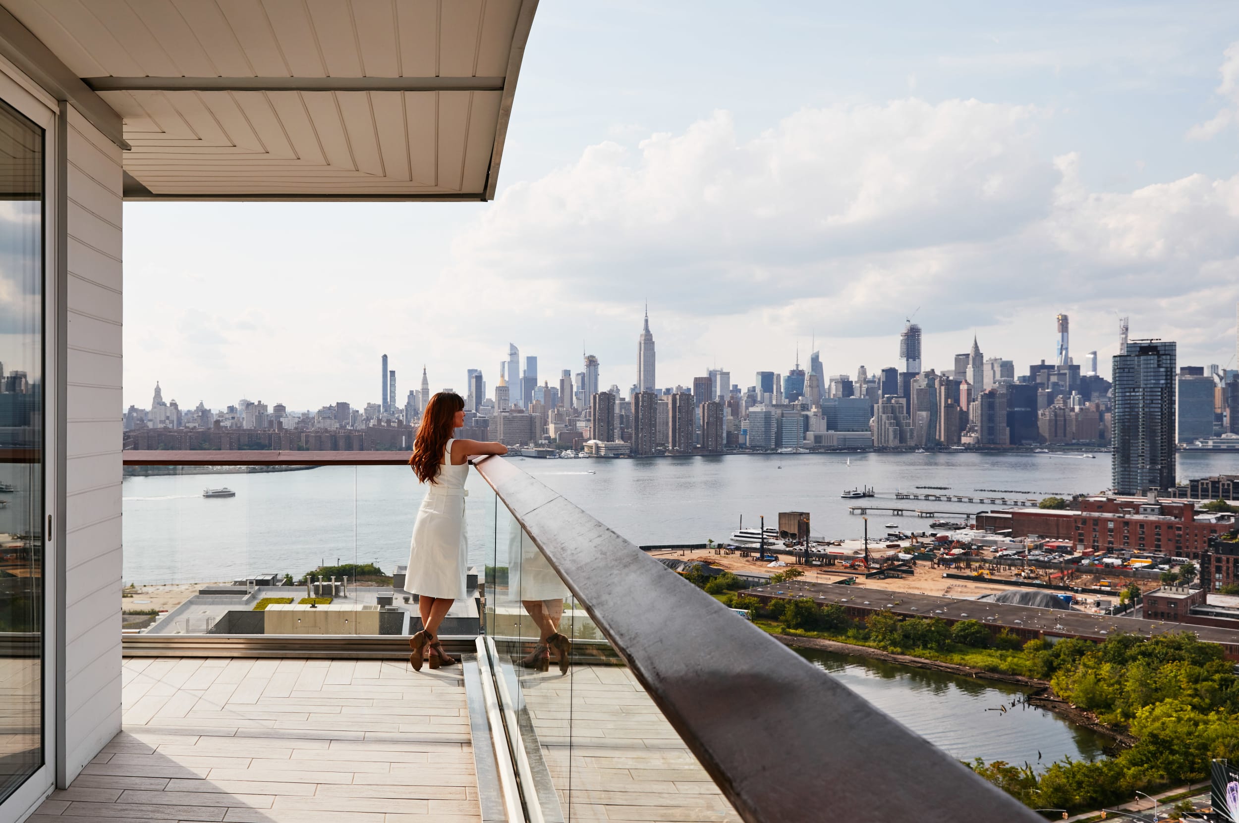 Gotham Corner Suite, woman enjoying the city view from the balcony Image