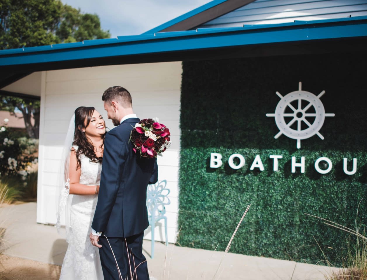 Newlyweds in front of boathouse