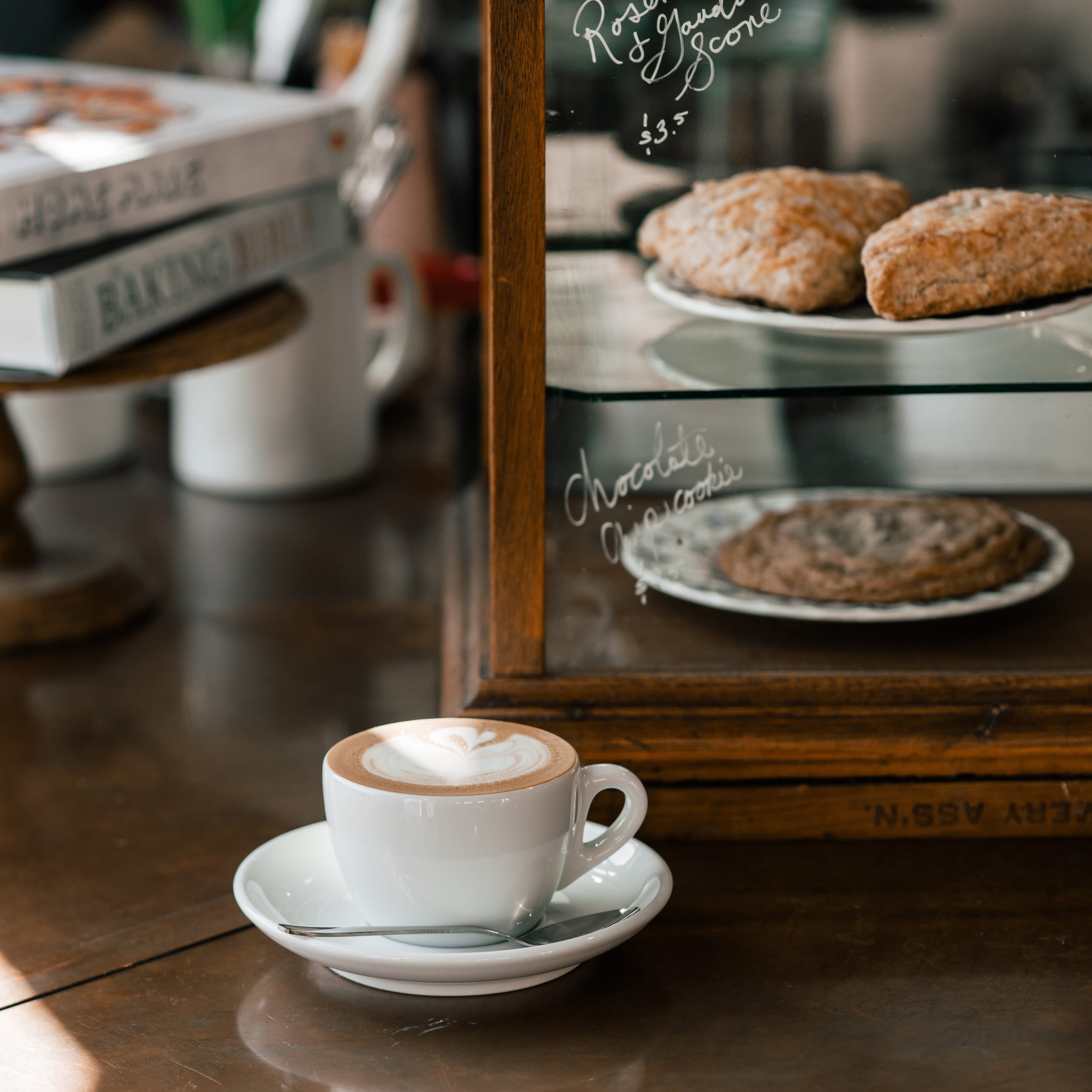 A cup of coffee in front of a pastry case