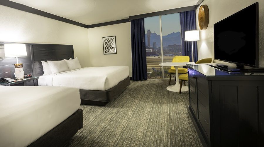 Two queen bed next to window with airport view