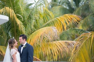 bride and groom in front of palm trees