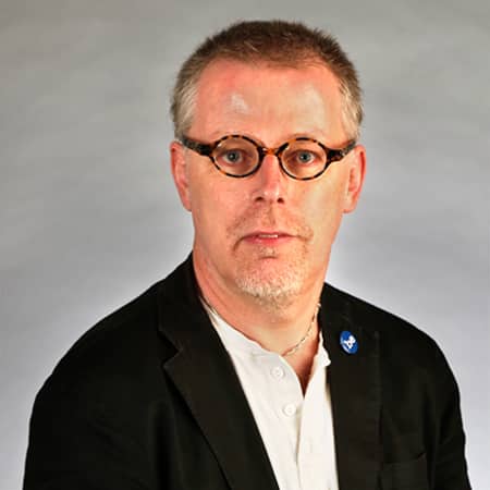 Image of Dr. Paul Caplan's face on in iPad, with him holding the iPad in front of his face.
