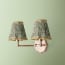 Double insignia wall fixture in antiqued brass