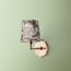 single insignia wall fixture in antiqued brass