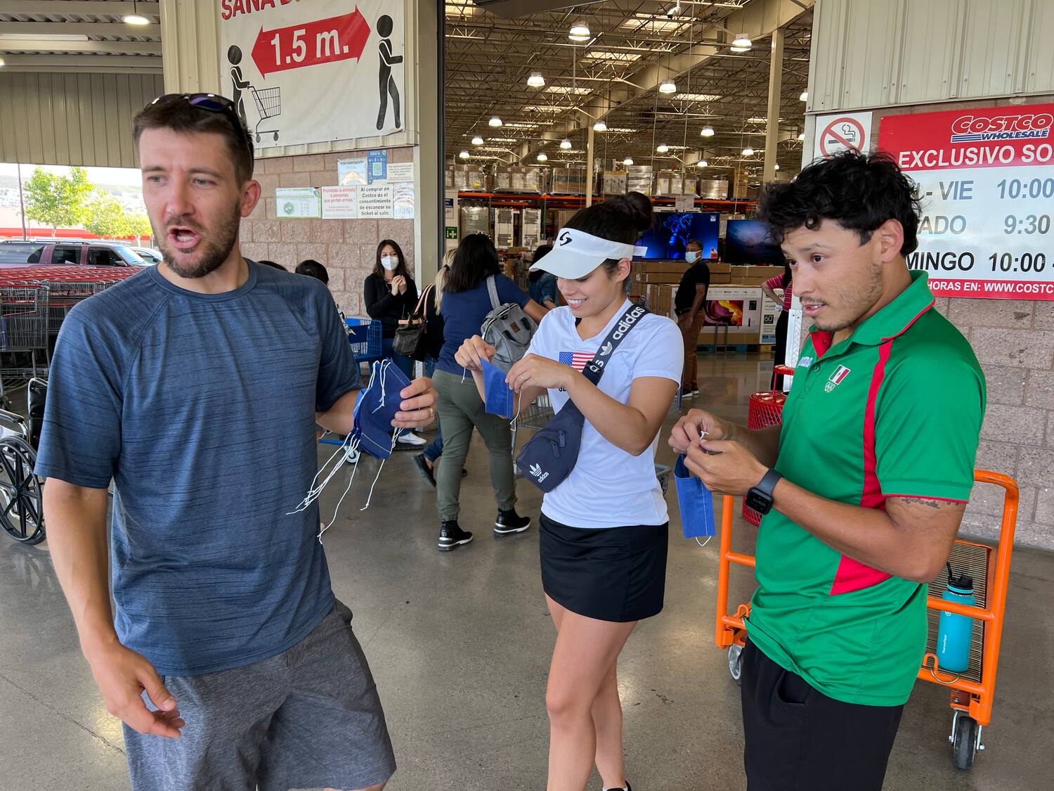 Charlie Pratt, Hollie Scott, and Daniel De La Rosa putting masks on before entering Costco.