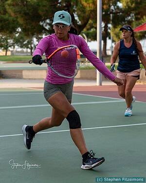 Female player hitting a racquetball.